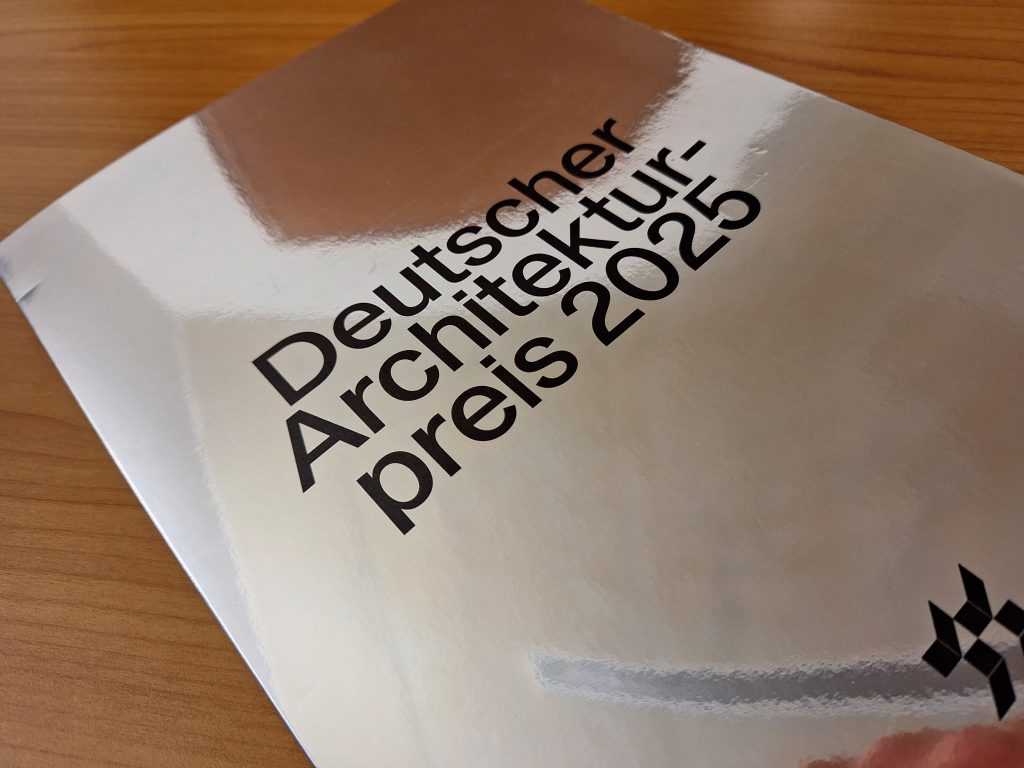 Broschüre des Deutschen Architekturpreises 2025 mit reflektierender Oberfläche.