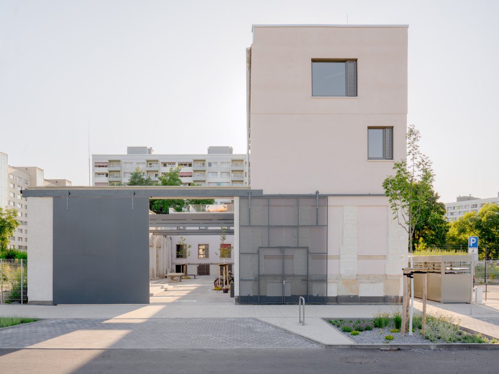 Bei der Preisverleihung zum „Bundespreis Umwelt & Bauen“ halten Alexander Pötzsch Architekturen und der Kinderschutzbund Ortsverband Dresden e.V. eine Urkunde vor blauem Hintergrund.