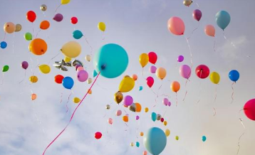 Zum Internationalen Kindertag steigen bunte Luftballons in den Himmel und erinnern an Kinderrechte, Sicherheit, Respekt und Chancen für Kinder.